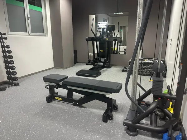 Area allenamento funzionale e rieducazione dello studio di Foligno con panca regolabile, rack manubri e macchinari professionali