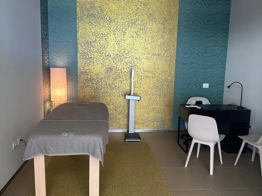 Sala osteopatia dello studio di Foligno: lettino al centro, bilancia per valutazione posturale e scrivania per anamnesi