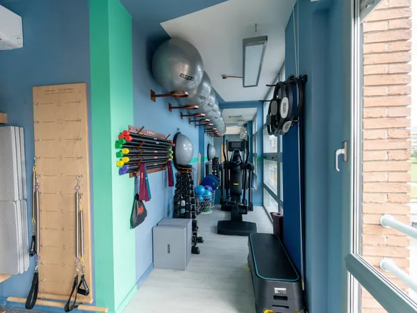 Area attrezzi dello studio di Spoleto con Pilates Springboard, fitball wall-mount, manubri, bastoni Sidea ed ellittica TechnoGym